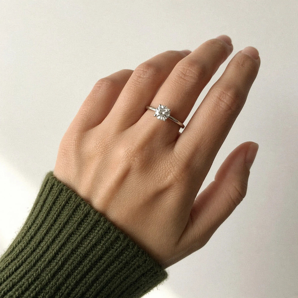 Four-prong round lab-grown diamond solitaire on the left ring finger